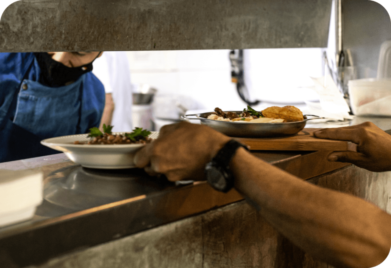 Garçom retirando pedidos na cozinha